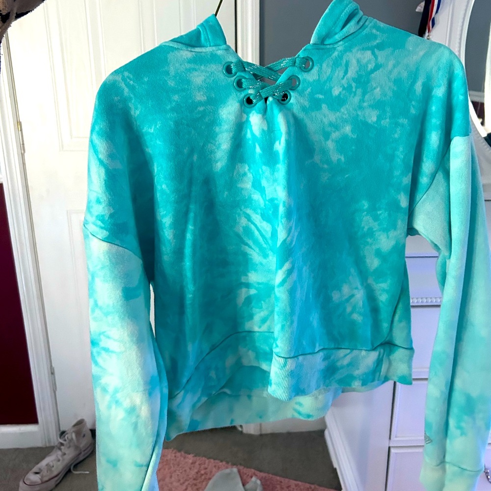 It’s a tye dye blue. Very bright turquoise blues and has cross detail at the top